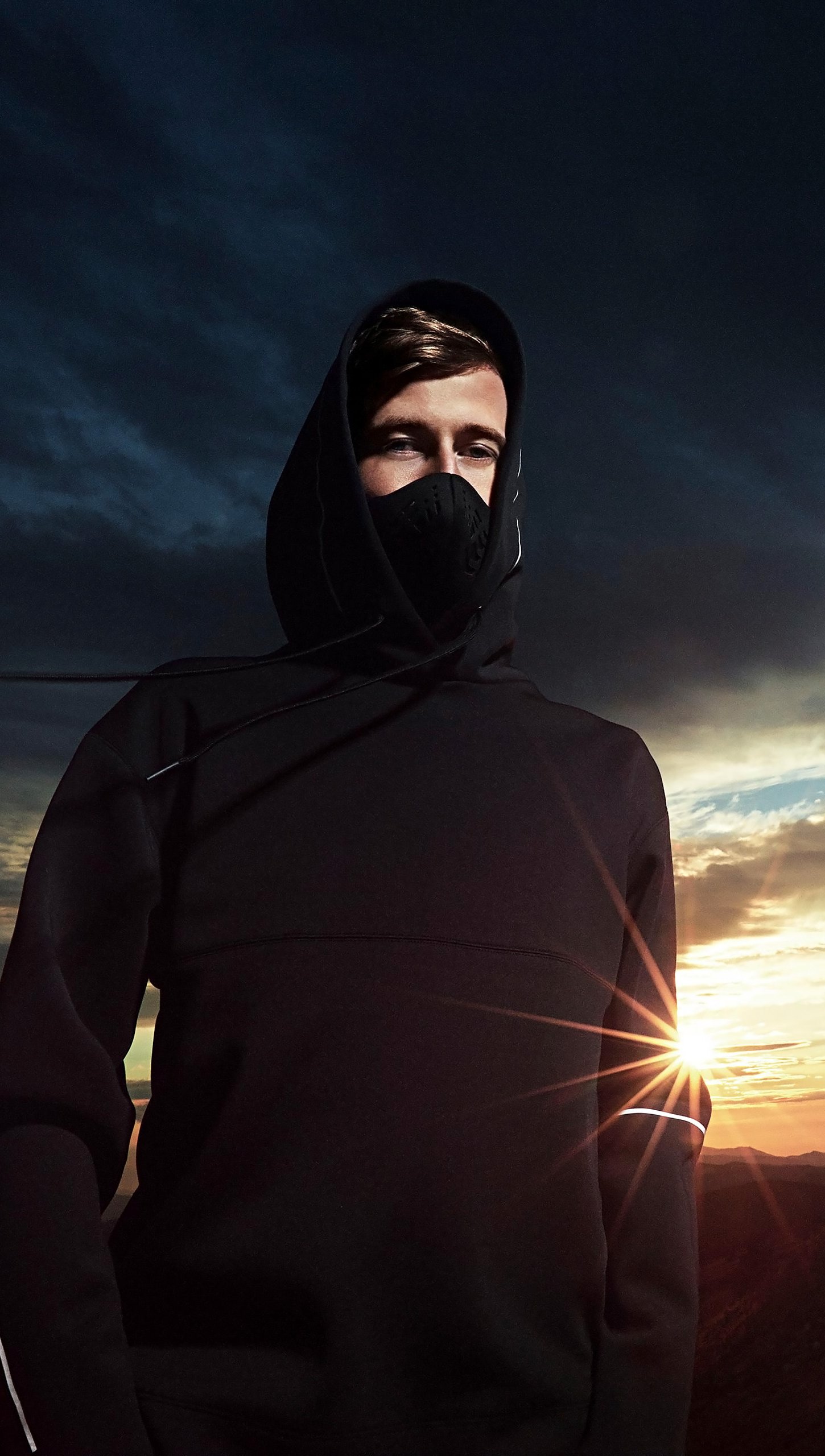 Alan Walker en paisaje de atardecer