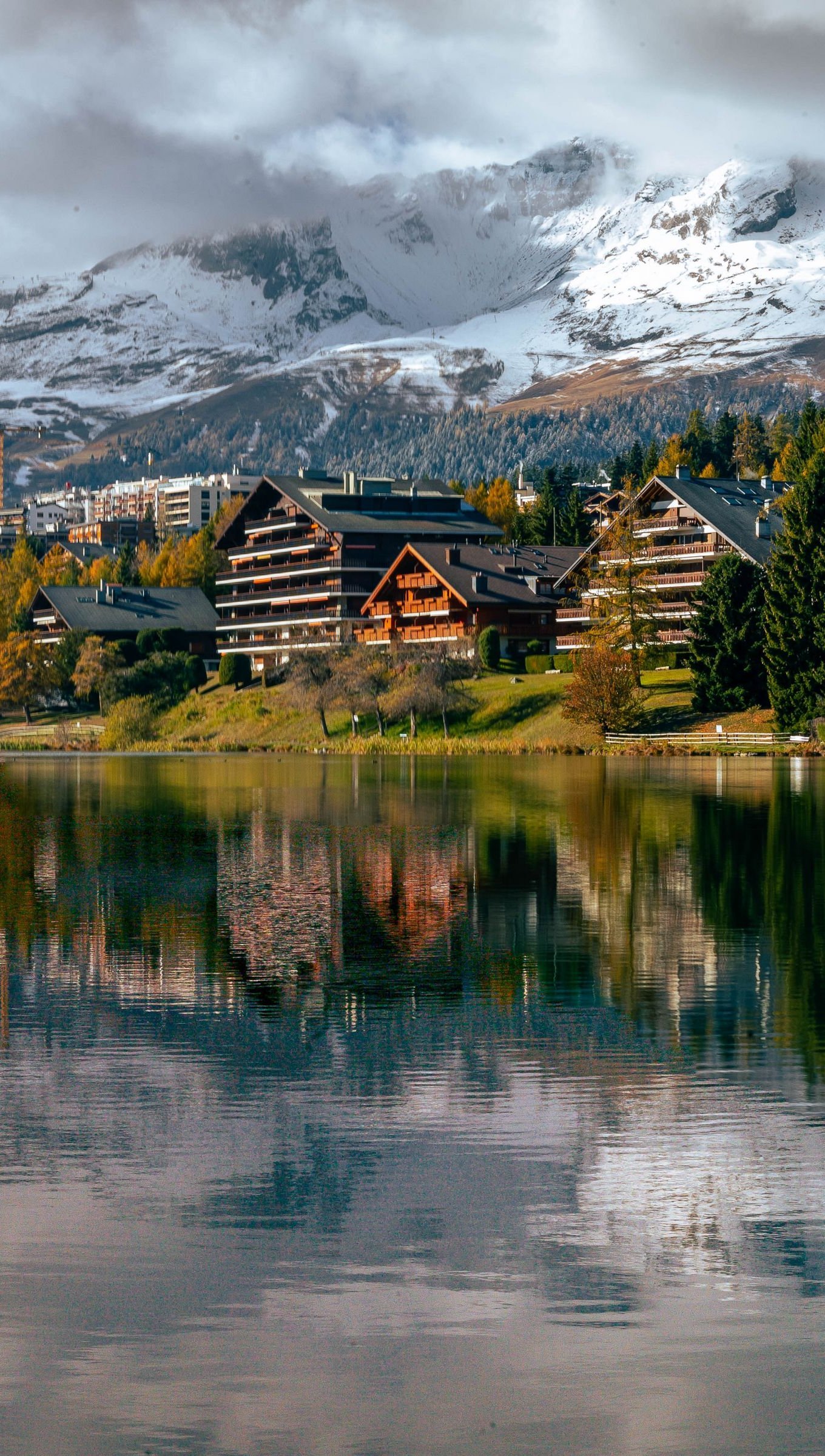 Bosque y cabañas reflejadas en lago