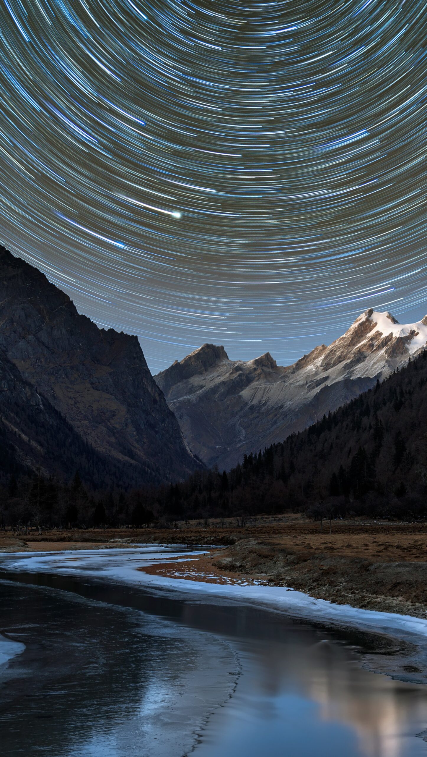 Estrellas en remolino en paisaje montañoso