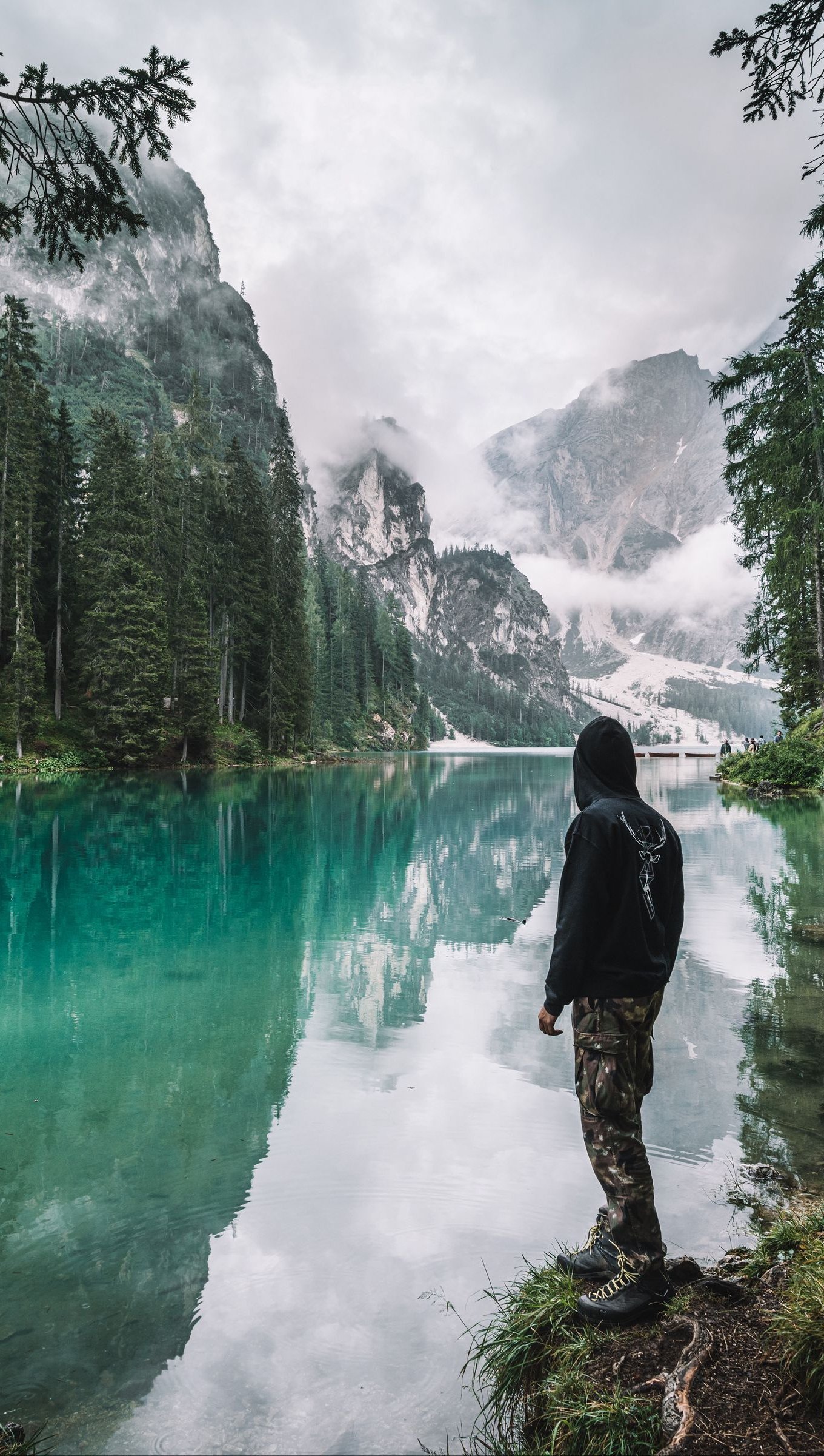 Hombre frente a lago en el bosque