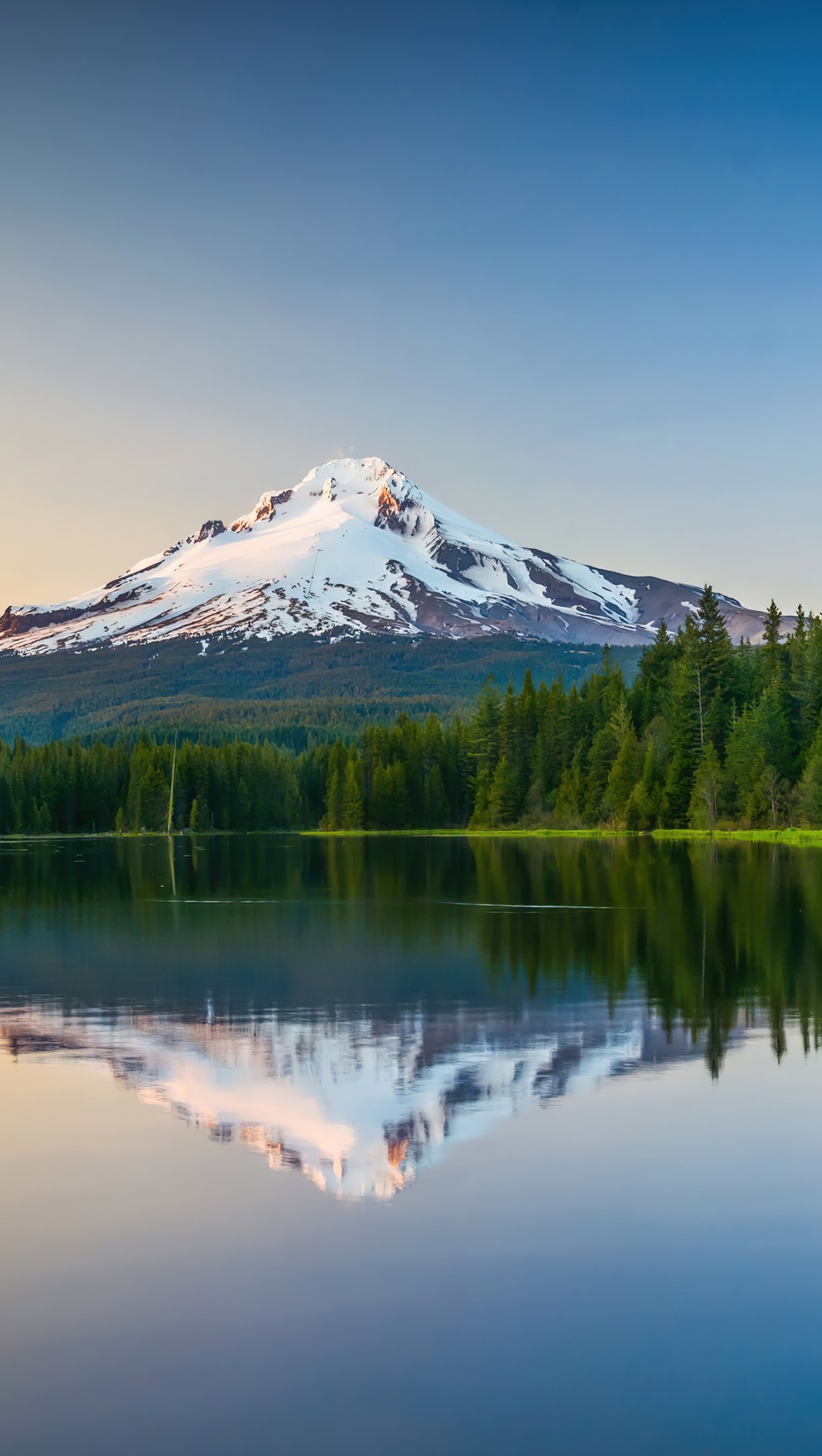 Lago reflejando las montañas y el bosque