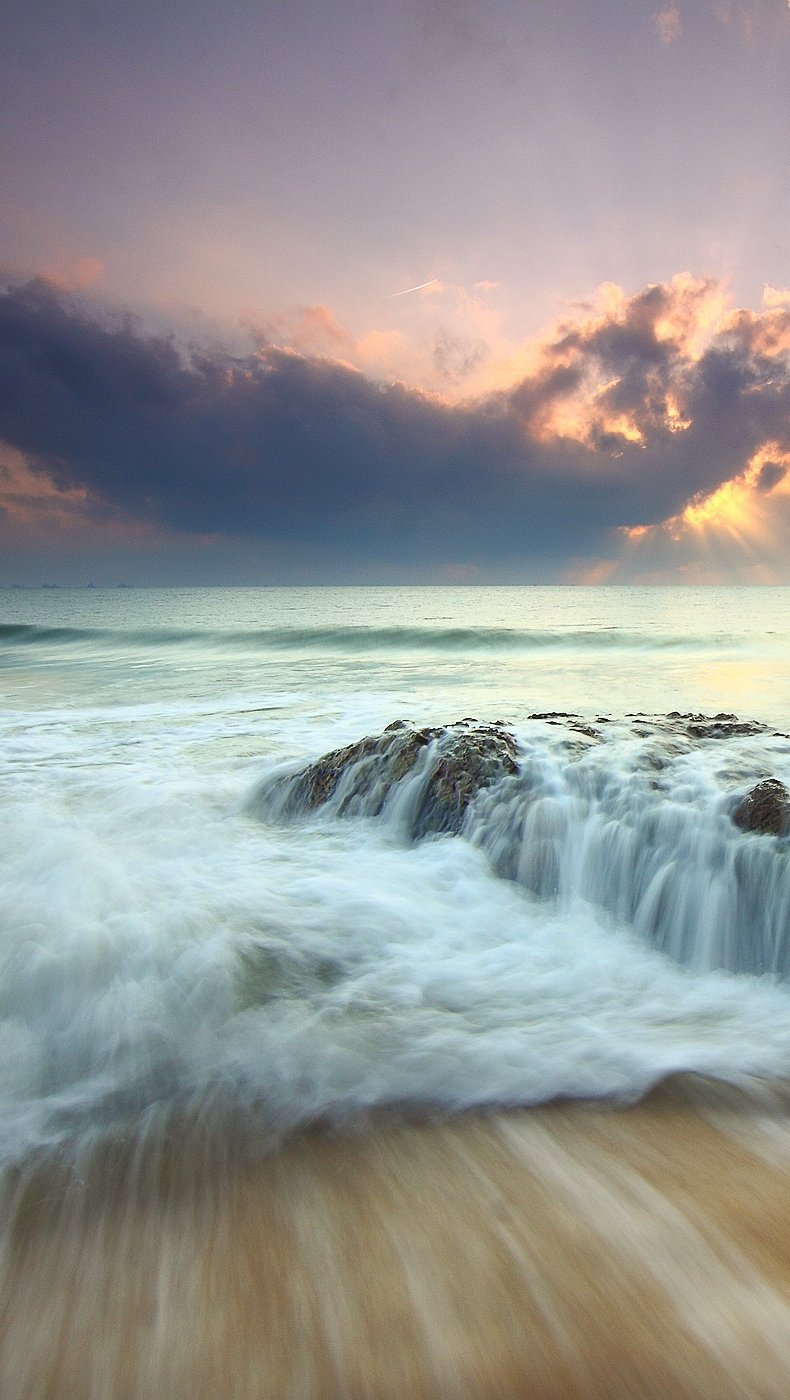 Las olas de la playa al atardecer