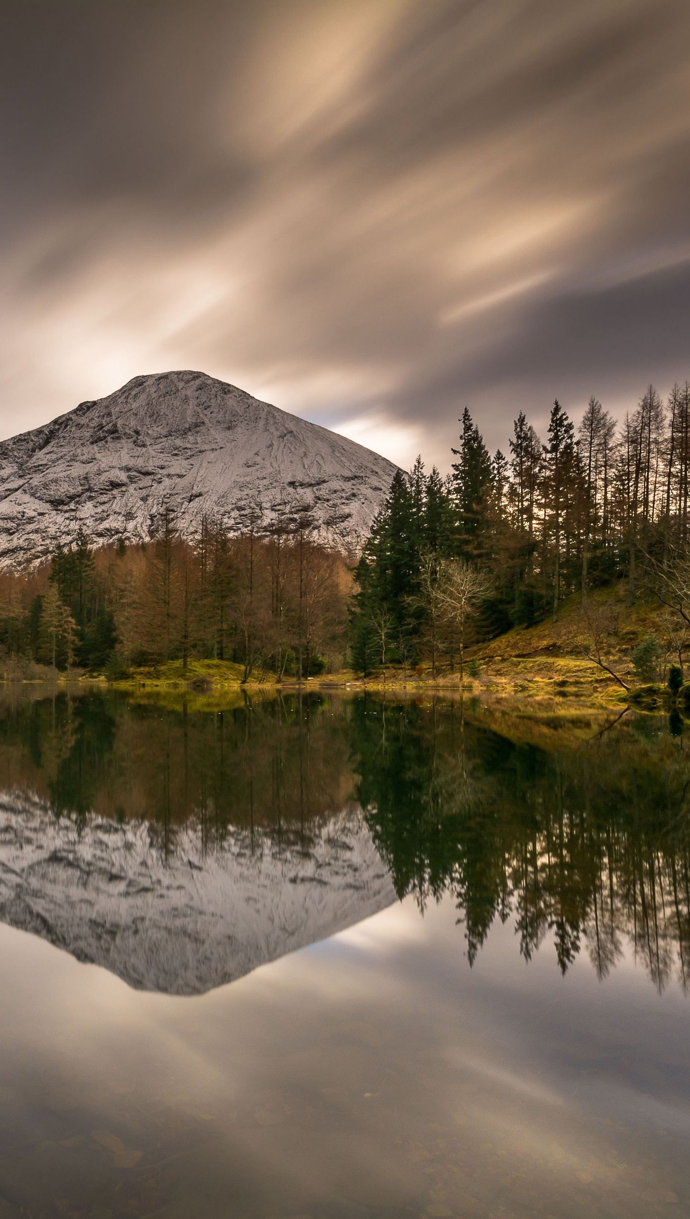 Montañas en el bosque reflejadas en lago día nublado