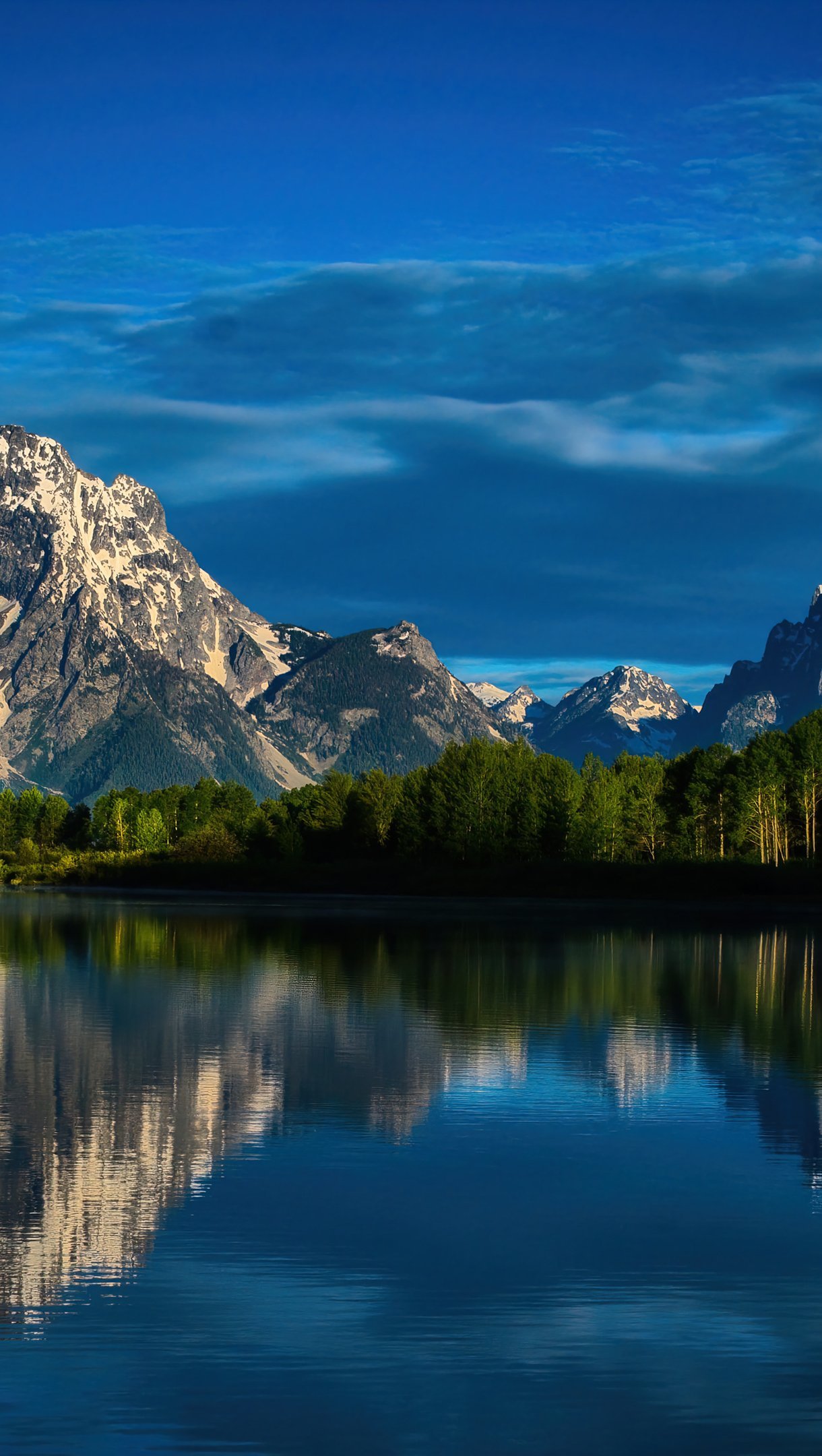 Montañas reflejadas en lago con el ciel azul