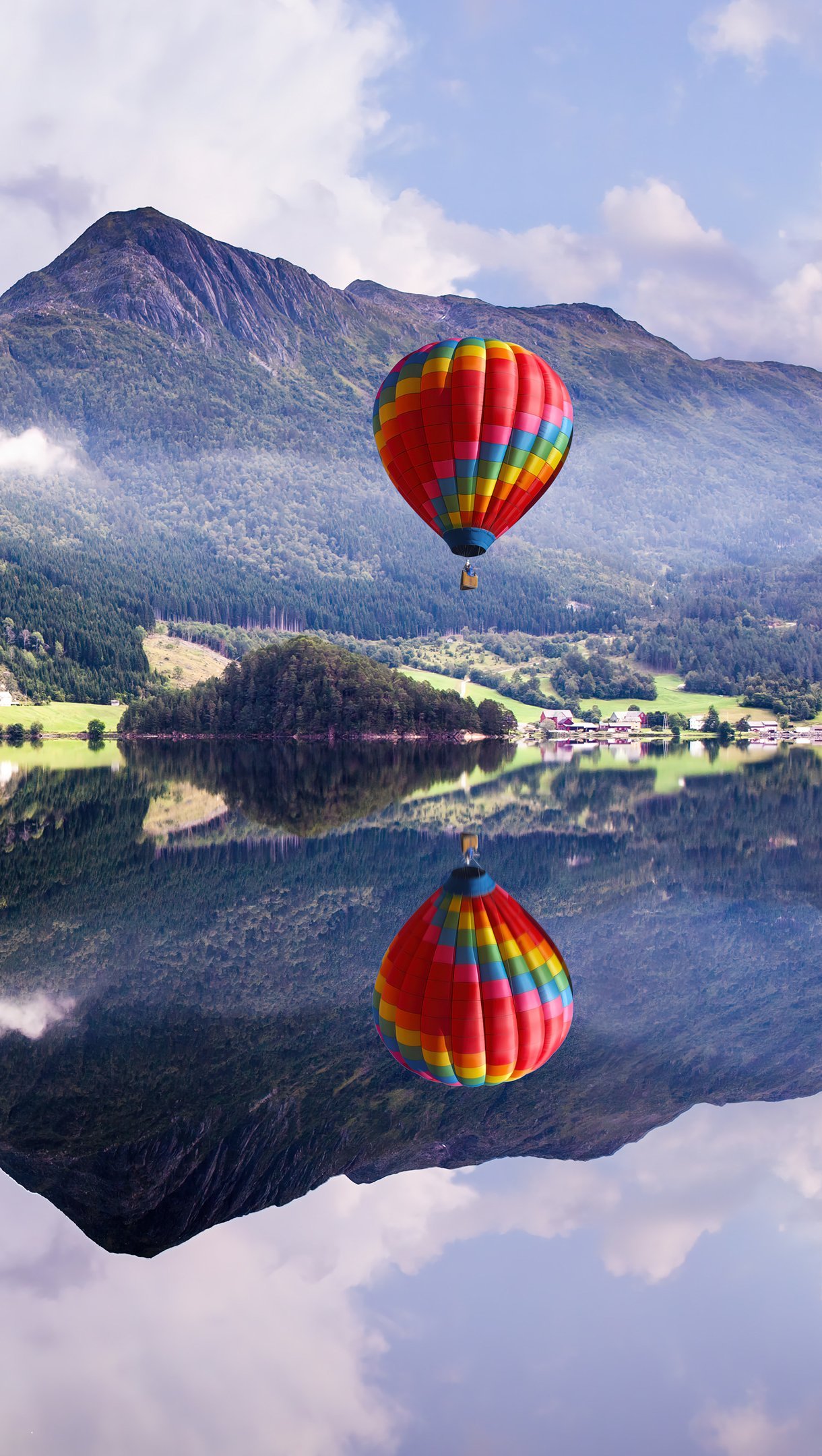 Montañas reflejadas en lago con globo aerostatico