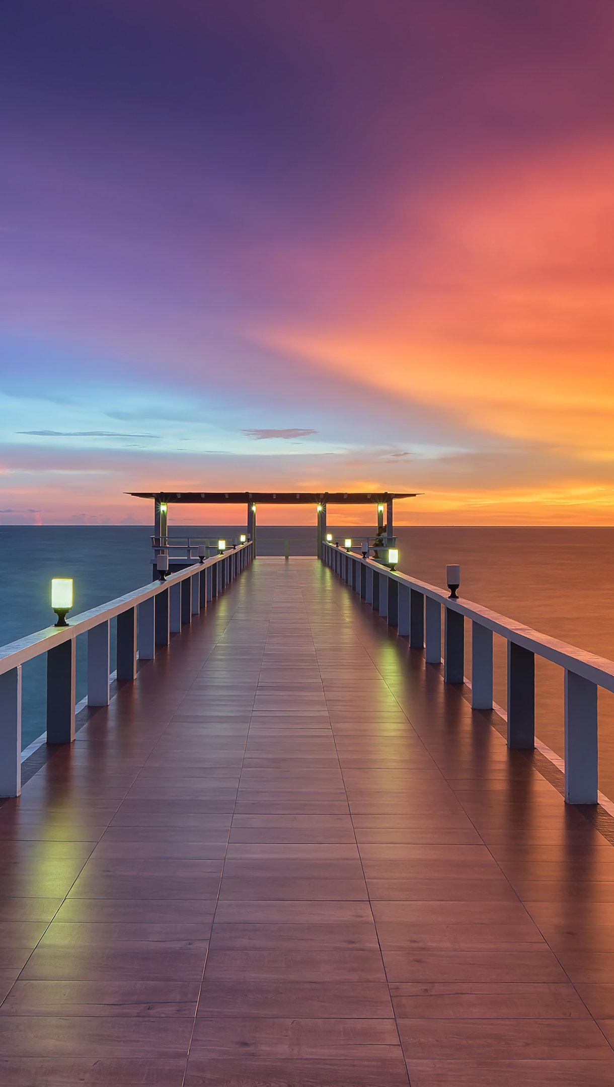 Muele de madera frente al mar al atardecer