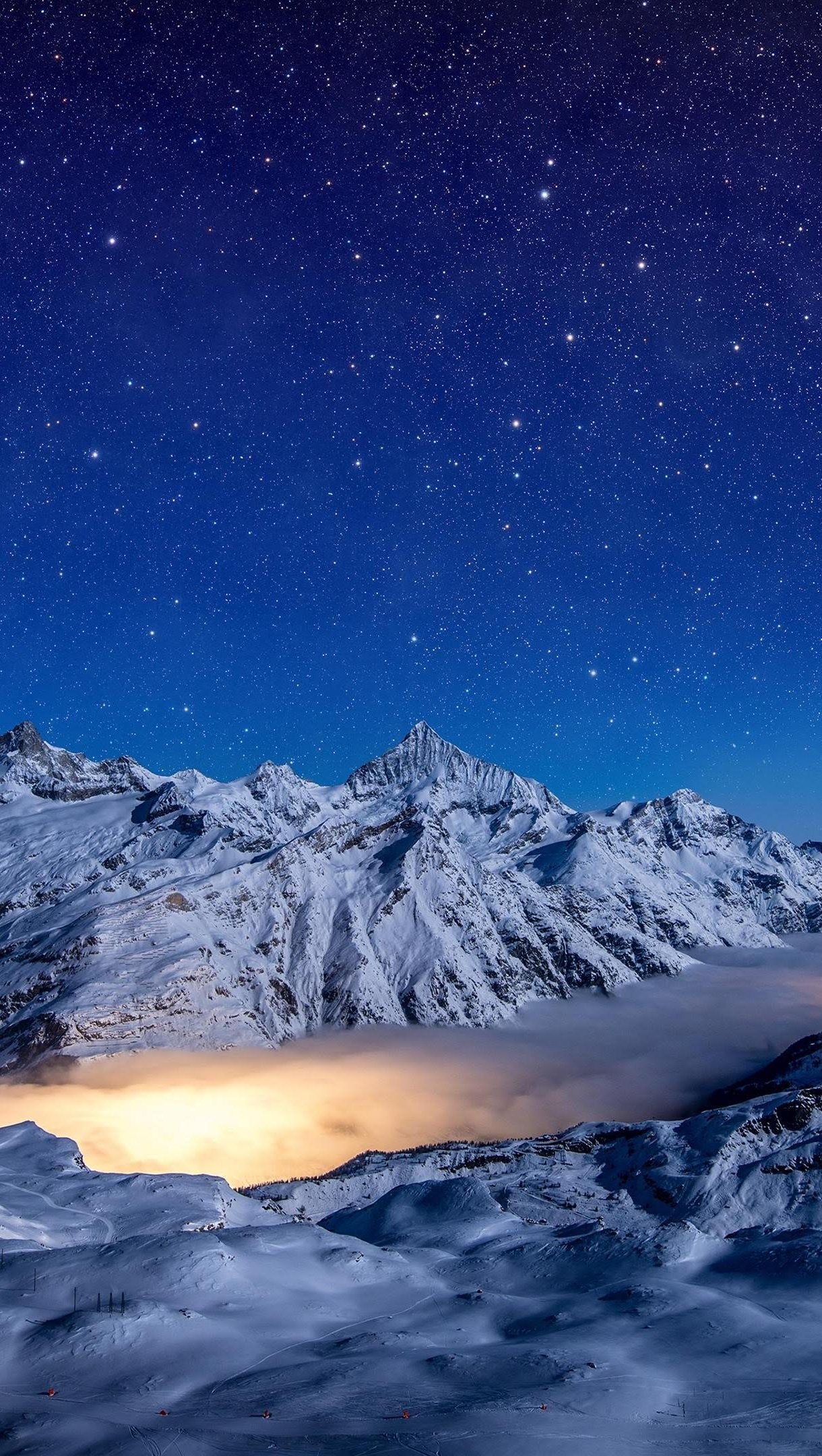 Noche con estrellas en paisaje montañosos con nieve