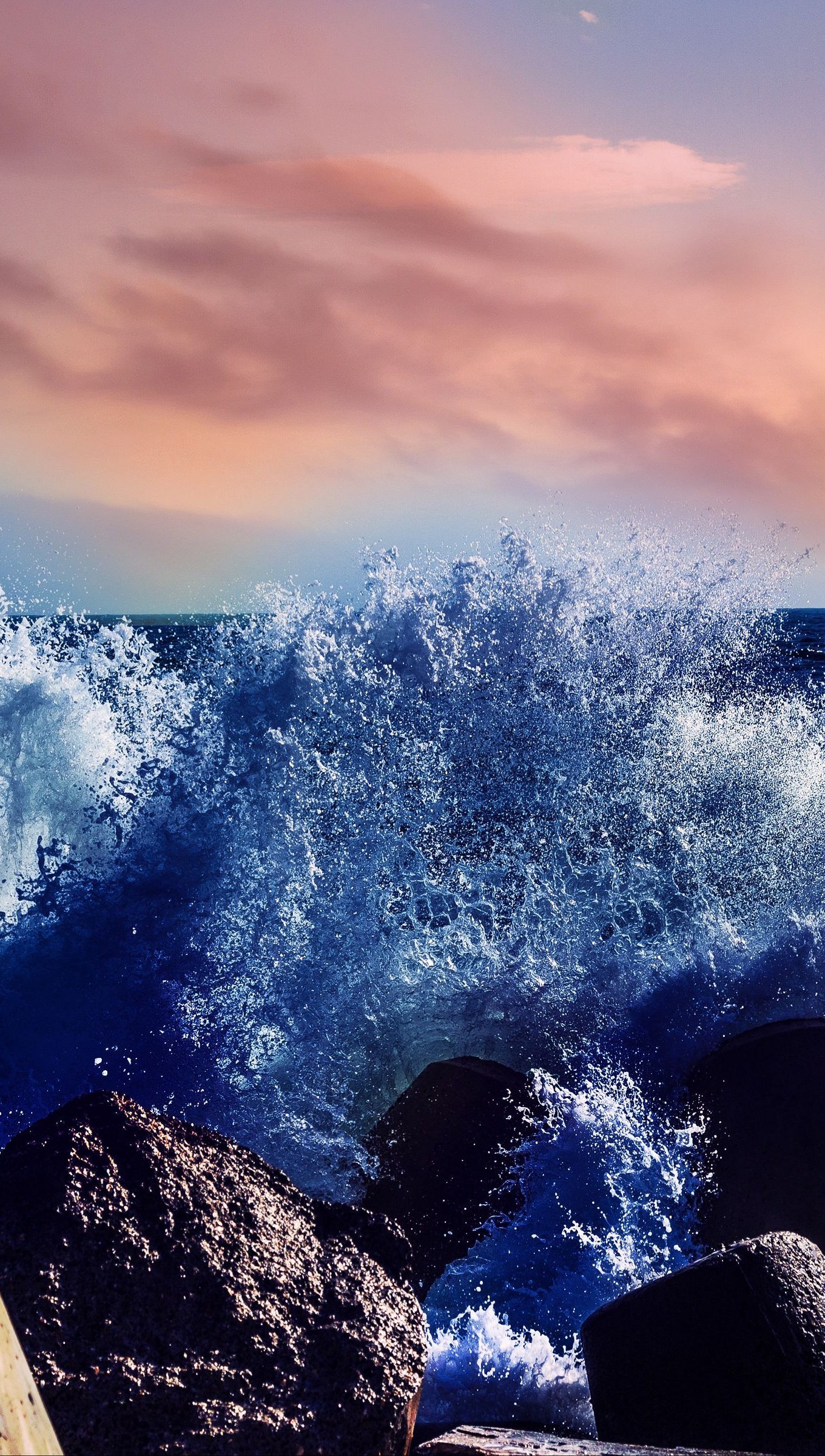 Olas chocando con rocas al atardecer