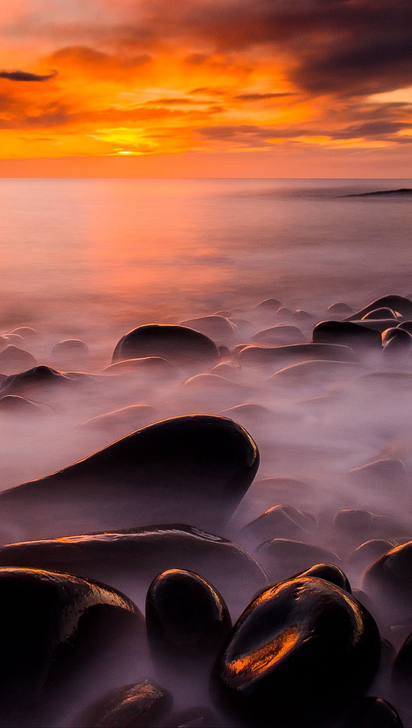 Rocas en el mar cubiertas de niebla